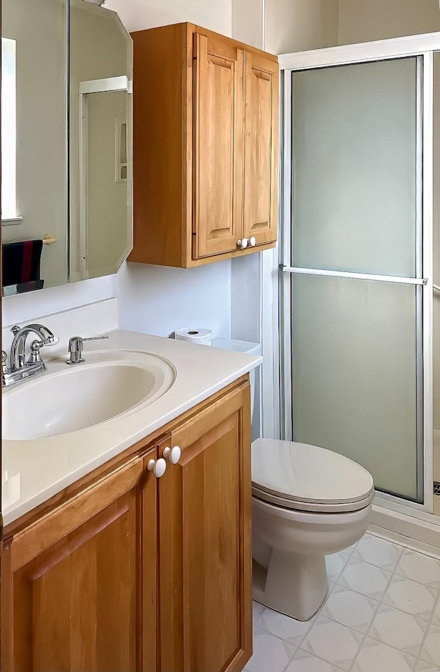 bathroom featuring toilet, vanity, and an enclosed shower