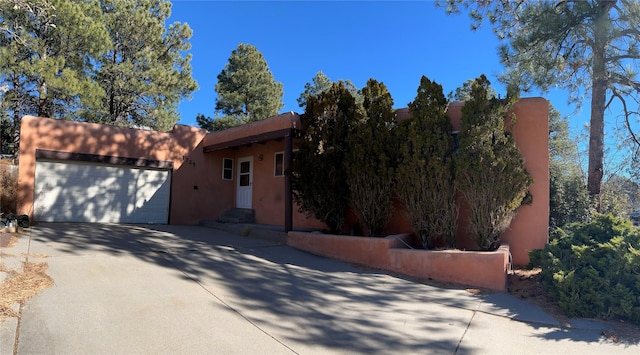 pueblo-style home featuring a garage