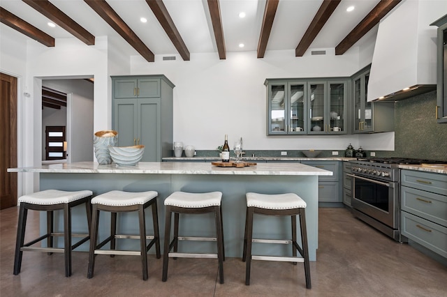 kitchen with decorative backsplash, a spacious island, high end stove, and custom exhaust hood