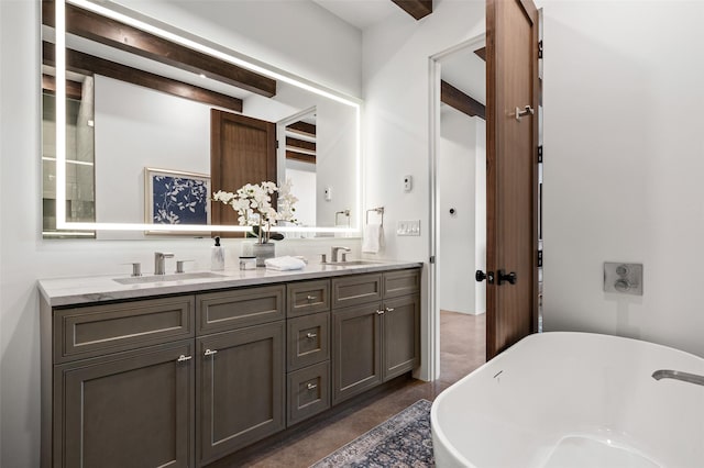 bathroom with beam ceiling, a tub to relax in, and vanity