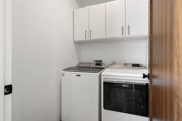 laundry area with cabinets and washer and clothes dryer