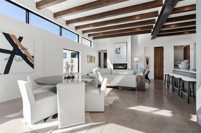 living room with beamed ceiling and concrete flooring