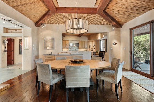 dining room featuring hardwood / wood-style flooring, lofted ceiling with beams, and a chandelier