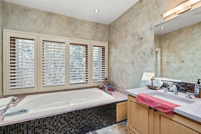 bathroom with a relaxing tiled tub and vanity