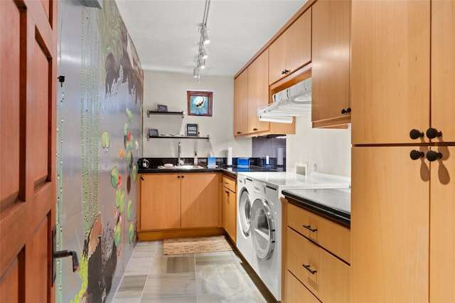 kitchen featuring washing machine and dryer, light tile patterned floors, light brown cabinetry, and sink