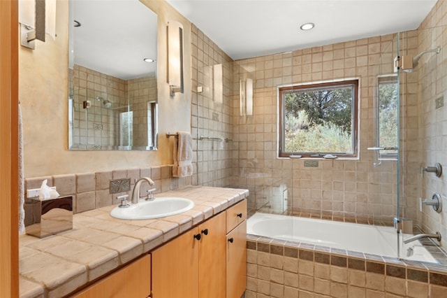 bathroom with tiled shower / bath combo and vanity