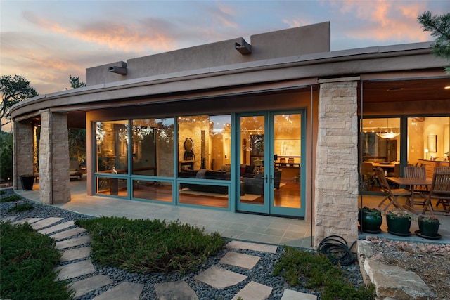 back house at dusk featuring a patio