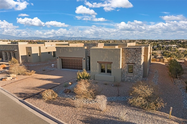 pueblo revival-style home with a garage and a mountain view