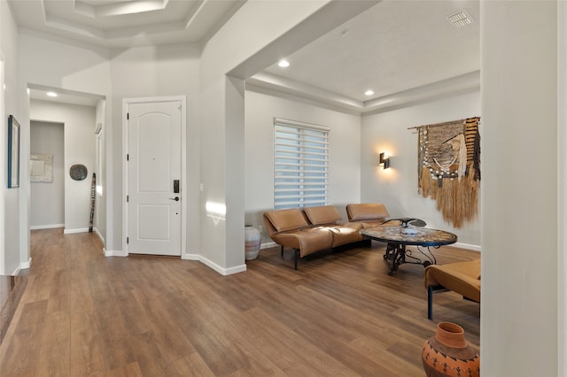 living room with hardwood / wood-style flooring and a raised ceiling