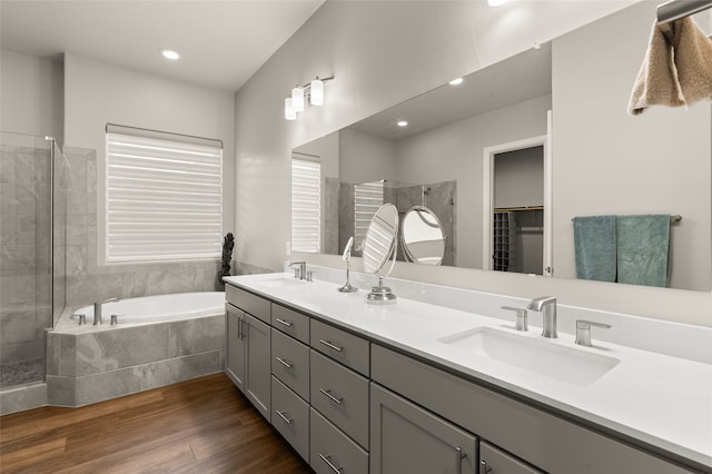 bathroom featuring separate shower and tub, hardwood / wood-style flooring, and vanity