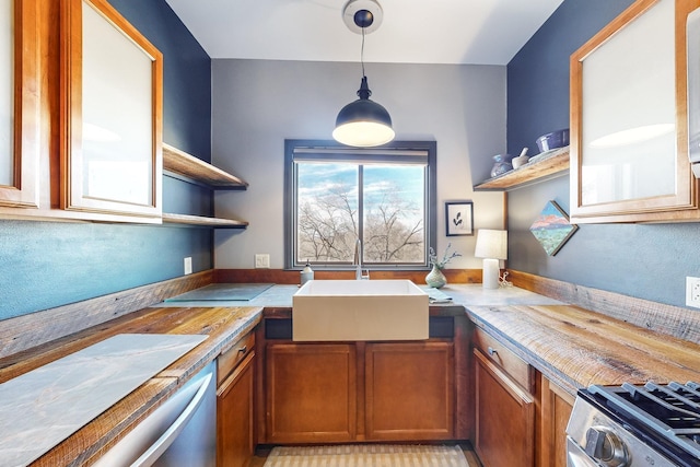 kitchen with decorative light fixtures, wood counters, appliances with stainless steel finishes, and sink