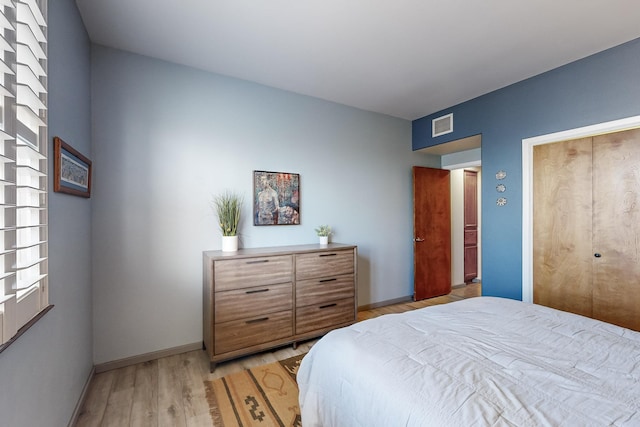 bedroom with light wood-type flooring and a closet