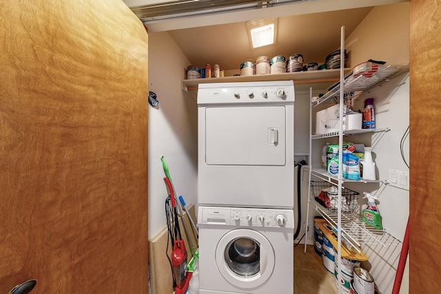 laundry area featuring stacked washing maching and dryer and tile patterned floors