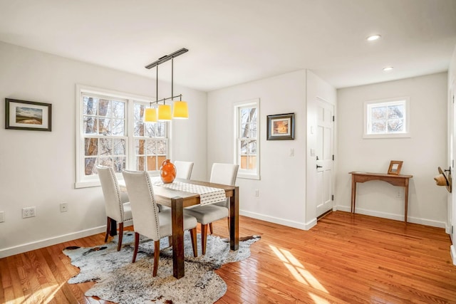 dining area with light wood-type flooring and a healthy amount of sunlight