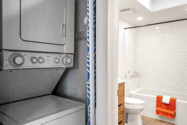 laundry room with stacked washer / dryer