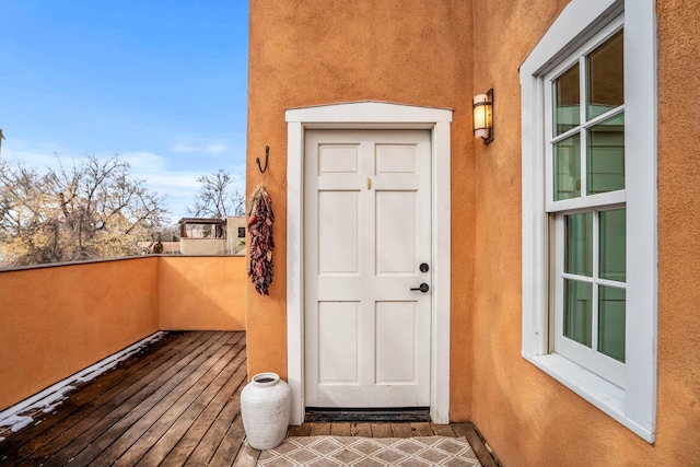 view of exterior entry with a balcony