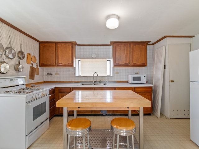 kitchen featuring crown molding, sink, tasteful backsplash, and white appliances