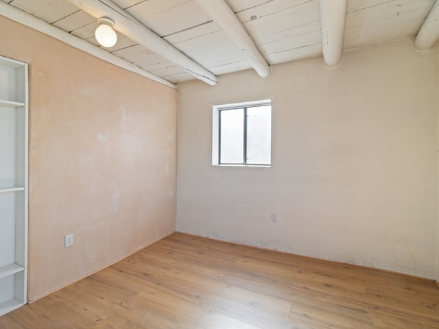 empty room with wooden ceiling, beam ceiling, and light hardwood / wood-style floors