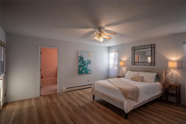 bedroom featuring a textured ceiling, wood-type flooring, a baseboard heating unit, ceiling fan, and ensuite bathroom