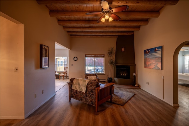 living room featuring wooden ceiling, beam ceiling, wood-type flooring, and ceiling fan