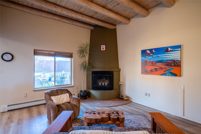 living room with wooden ceiling, light wood-type flooring, baseboard heating, a large fireplace, and beamed ceiling