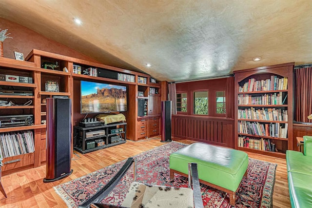 sitting room featuring vaulted ceiling, a textured ceiling, and light hardwood / wood-style flooring