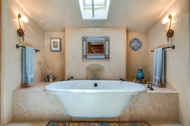 bathroom featuring a skylight and a bath