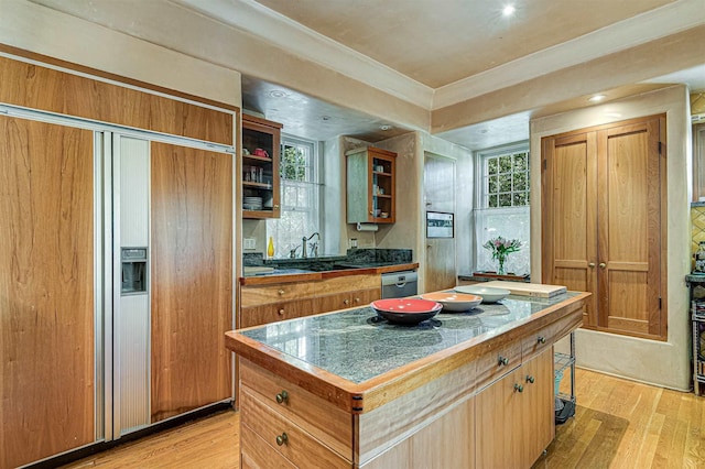 kitchen featuring stainless steel dishwasher, light hardwood / wood-style floors, and a center island