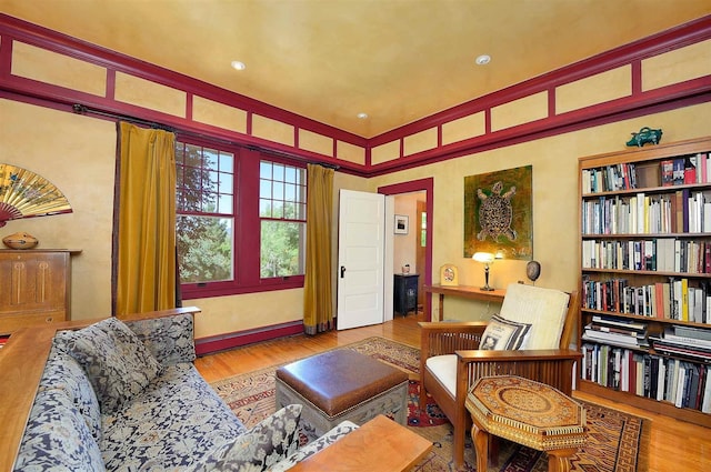 living area featuring a baseboard heating unit and light hardwood / wood-style flooring