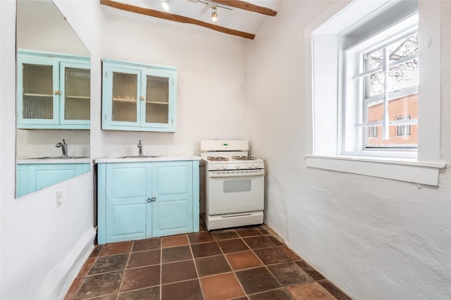 kitchen featuring sink, a wealth of natural light, white range with gas cooktop, and beam ceiling