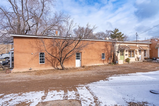 view of snow covered back of property