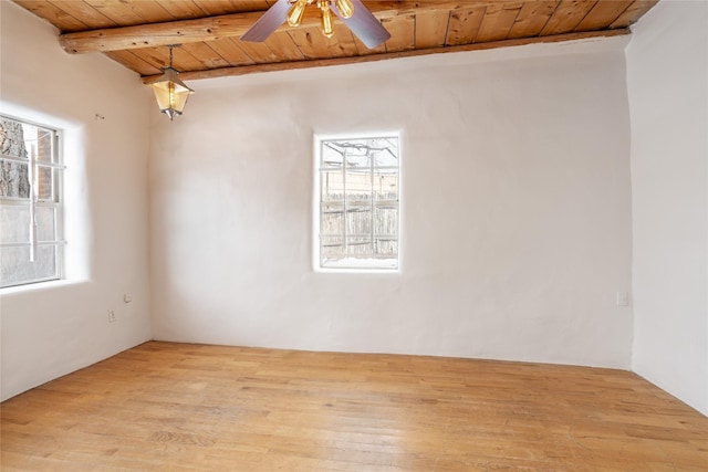 unfurnished room with light hardwood / wood-style flooring, wooden ceiling, beam ceiling, and plenty of natural light