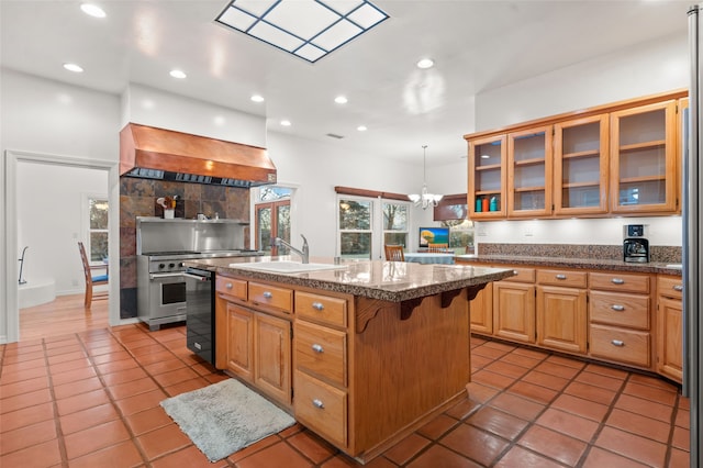 kitchen featuring a center island with sink, custom range hood, pendant lighting, a breakfast bar, and sink