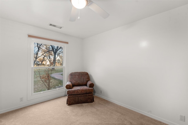 sitting room with ceiling fan, light colored carpet, and plenty of natural light