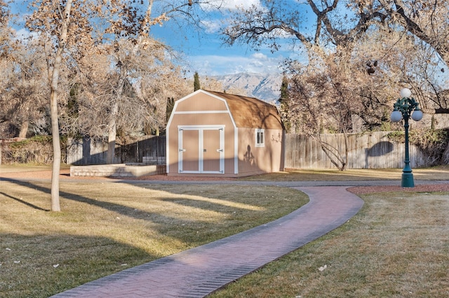 view of outbuilding featuring a mountain view and a yard