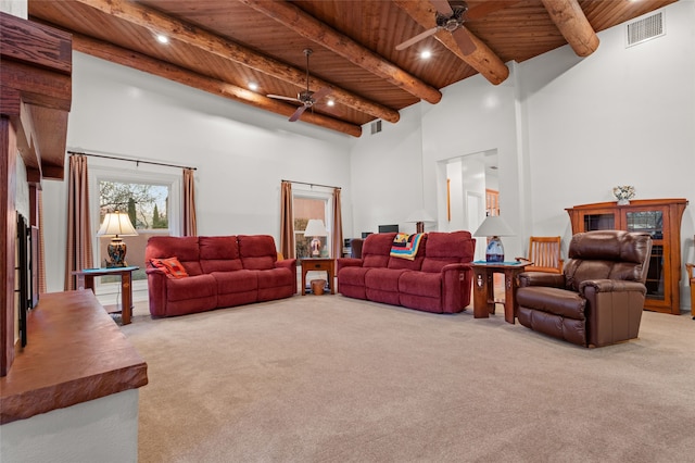 living room with a high ceiling, light colored carpet, beamed ceiling, and wood ceiling