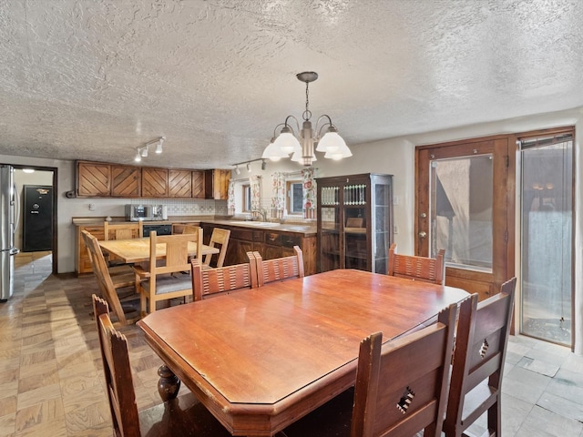 dining area featuring a textured ceiling and a notable chandelier