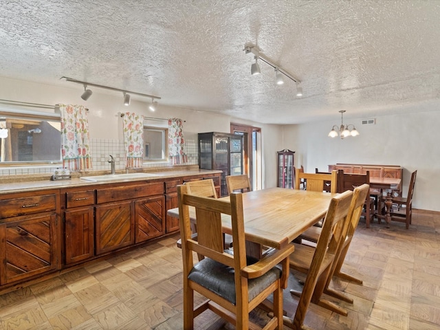 dining room with visible vents, a textured ceiling, and an inviting chandelier