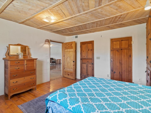 bedroom featuring wood ceiling, visible vents, and light wood finished floors