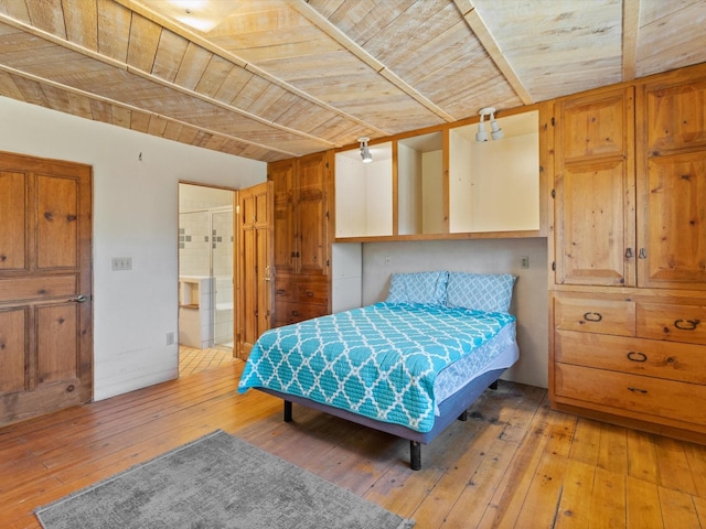 bedroom with light wood-style flooring, lofted ceiling, wooden ceiling, and ensuite bathroom