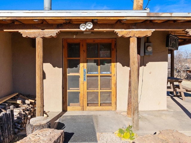 entrance to property with stucco siding and french doors