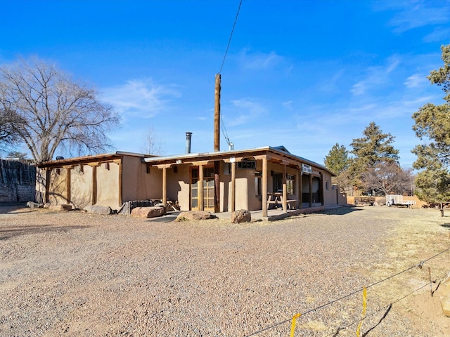 rear view of house featuring stucco siding