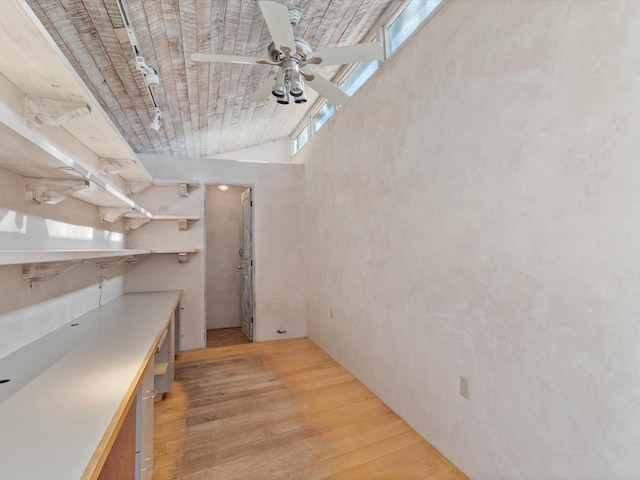 interior space with light wood finished floors, light countertops, and a ceiling fan