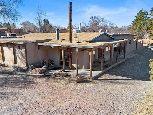 rear view of property with stucco siding and a patio