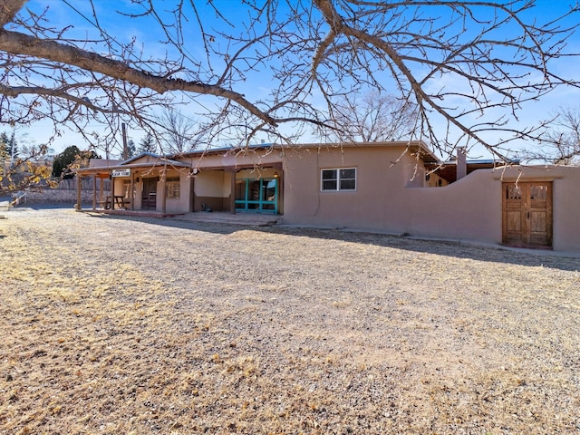 rear view of house featuring a patio and stucco siding