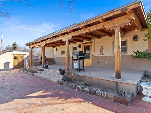 view of patio / terrace featuring an outbuilding and a grill