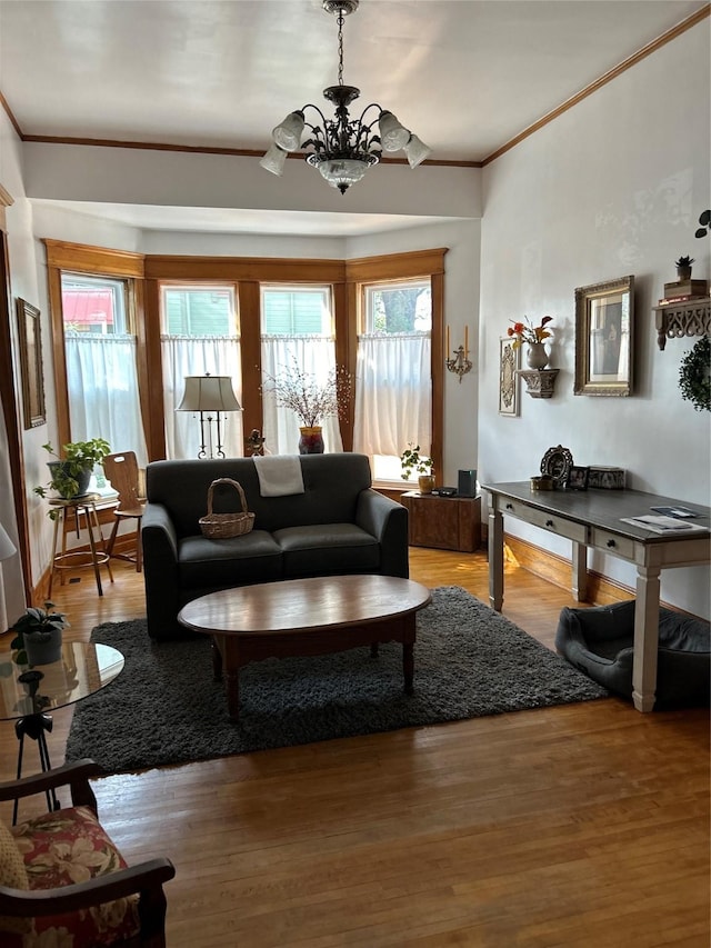 living room with hardwood / wood-style floors, ornamental molding, a chandelier, and a healthy amount of sunlight