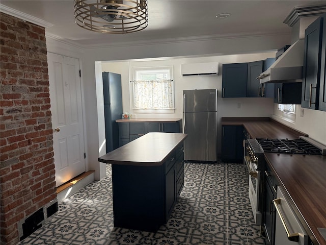 kitchen with butcher block countertops, appliances with stainless steel finishes, a wall mounted AC, and a kitchen island