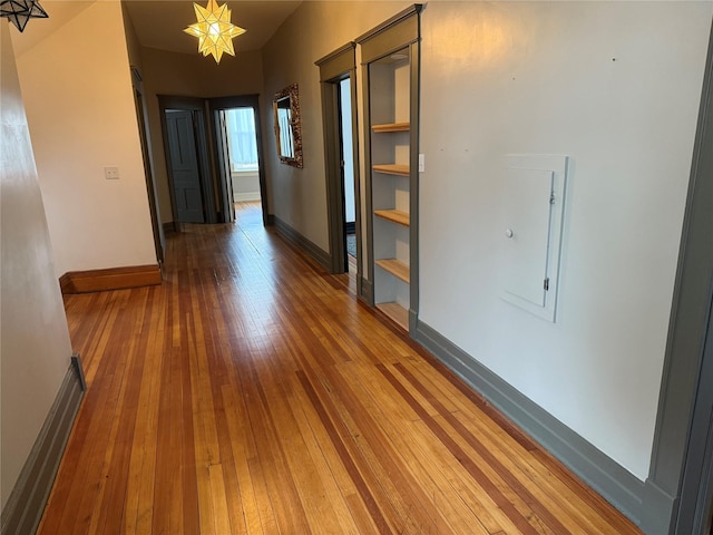 hall featuring a chandelier and hardwood / wood-style flooring