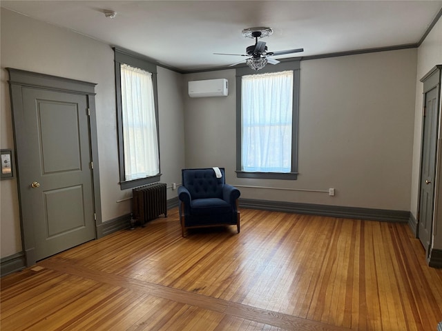 unfurnished room featuring ceiling fan, a healthy amount of sunlight, a wall mounted AC, and radiator heating unit